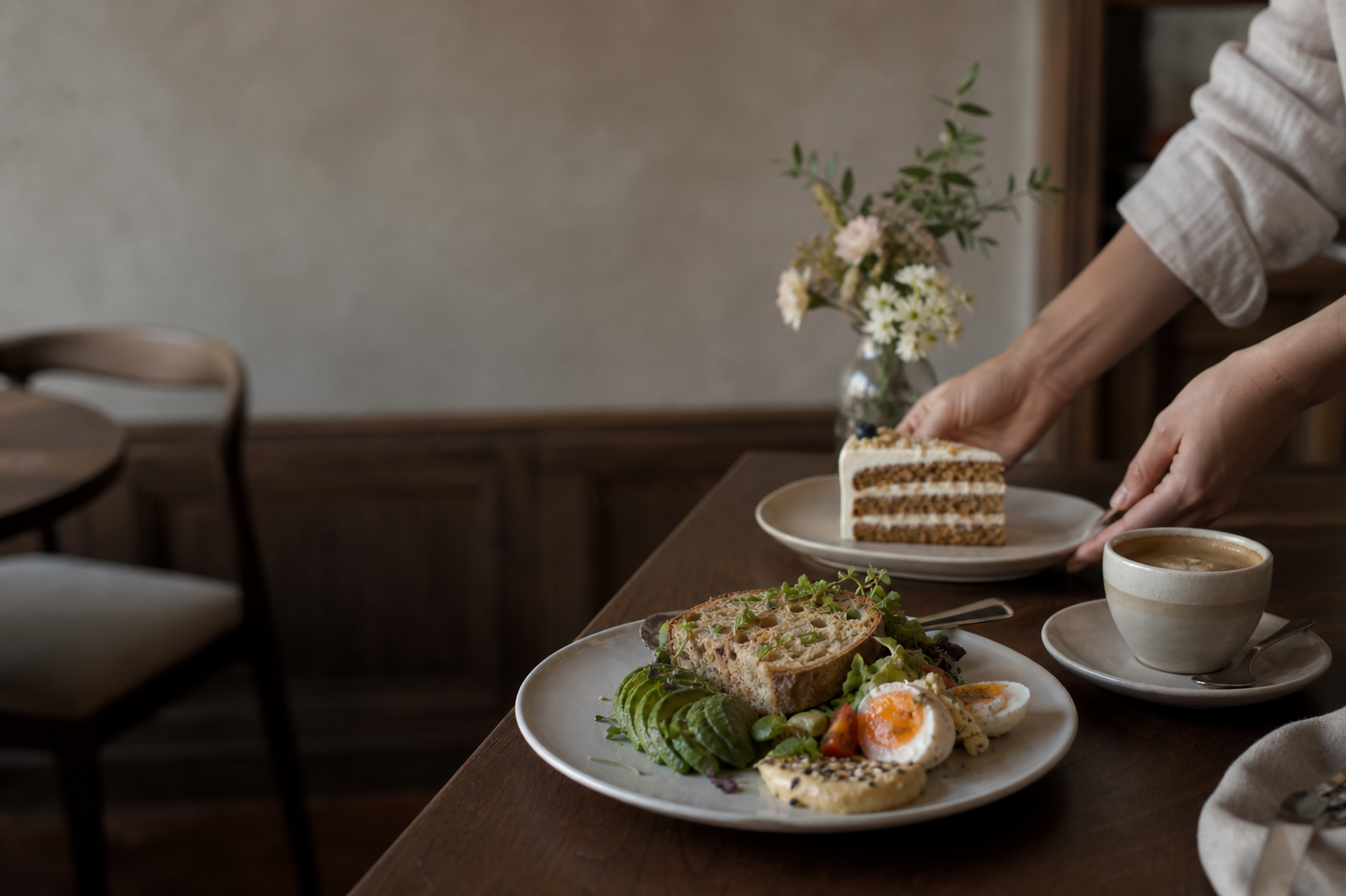 Ein liebevoll gedeckter Cafétisch mit Frühstück, Kuchen und Kaffee